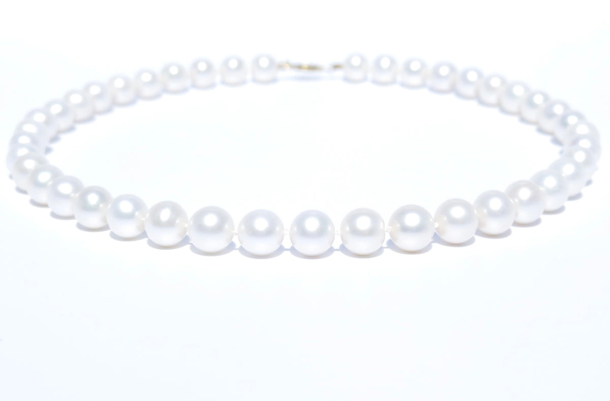 This pearl jewelry is a work of art and each pearl is hand-picked and matched in Guelph, Ontario, Canada. This elegant and gorgeous white pearl necklace is handmade with 100% cultured freshwater pearls, 18K yellow gold and silk thread. Pearl Size: 9.5-10.5 mm; Pearl Strand Length: 46 cm. 